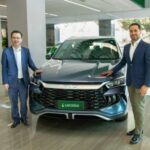 Executivos da BYD e Localiza&Co posam para foto ao lado de carro da BYD