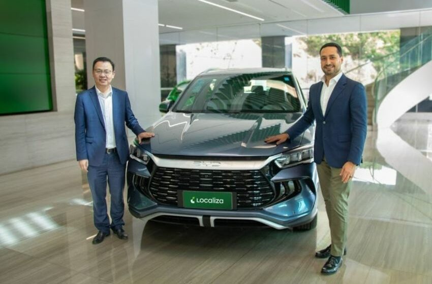 Executivos da BYD e Localiza&Co posam para foto ao lado de carro da BYD