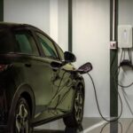 Carro elétrico recebe recarga em estacionamento de prédio