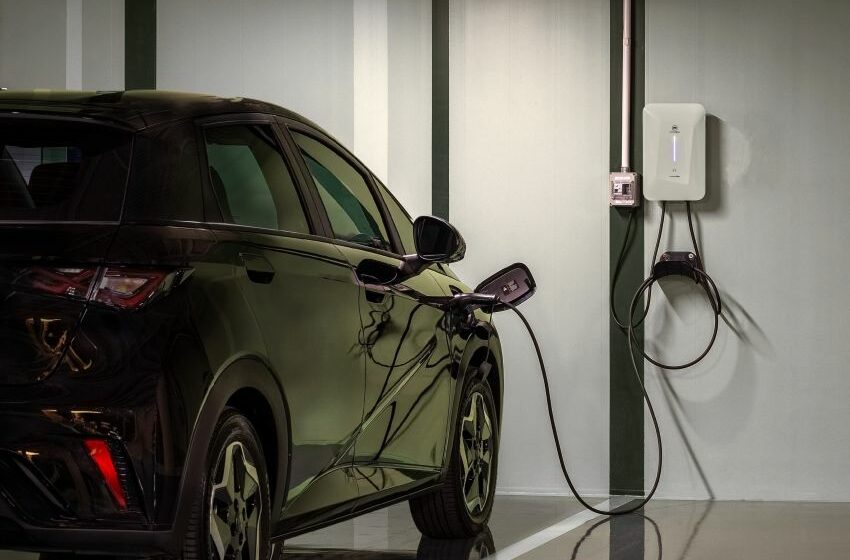 Carro elétrico recebe recarga em estacionamento de prédio