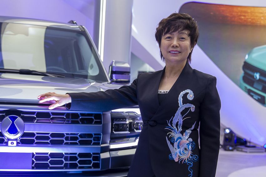 Stella Li posa para foto ao lado de carro da Denza