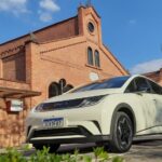 BYD Dolphin estacionado em frente a construção antiga