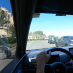 Visão interna do BYD Dolphin Mini circulando por avenida