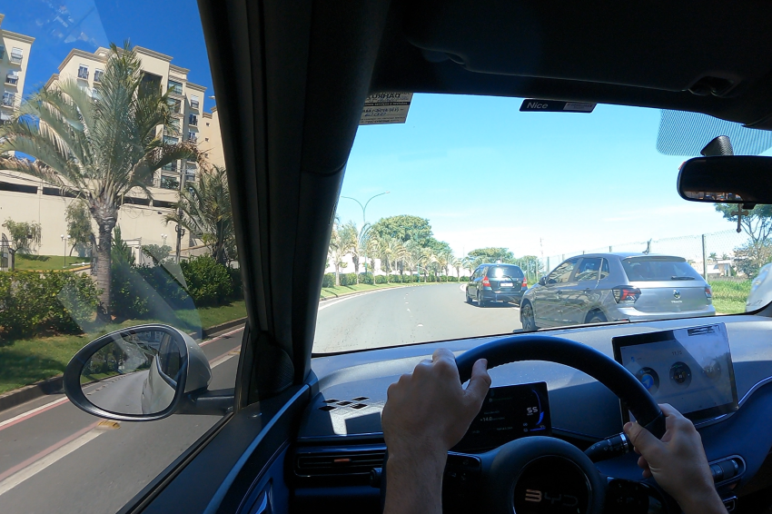 Visão interna do BYD Dolphin Mini circulando por avenida