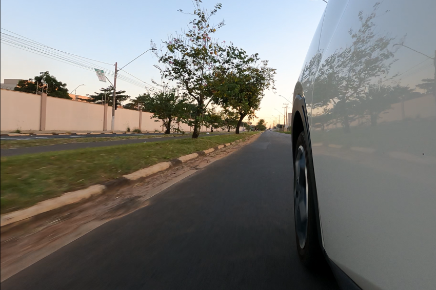 Visão lateral de um BYD Dolphin Mini circulando em avenida