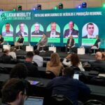 Executivos sentados em palco montado no evento