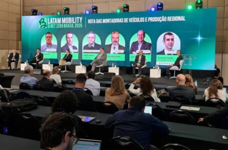 Executivos sentados em palco montado no evento