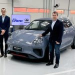 Executivos posam para foto ao lado de carro