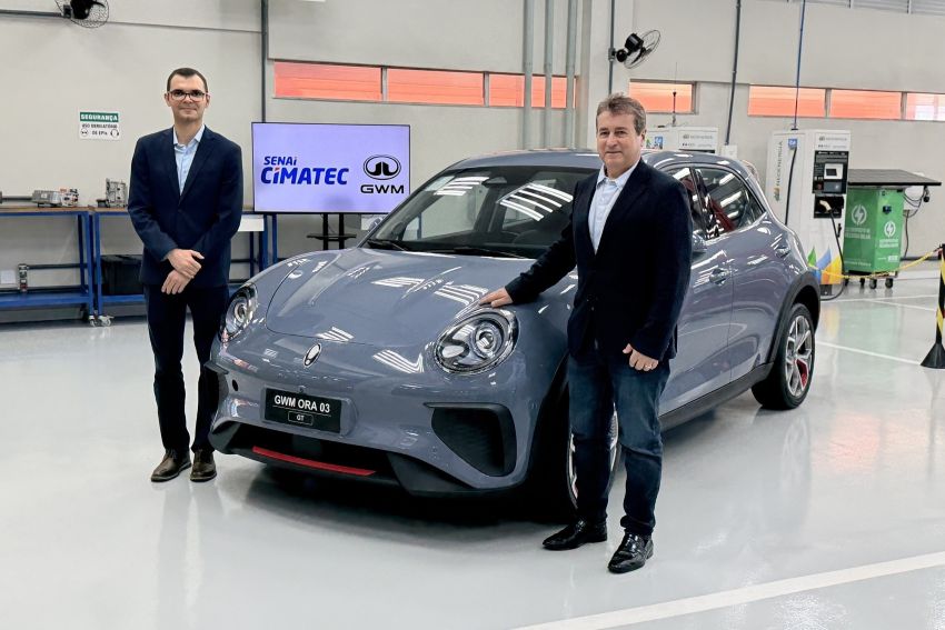 Executivos posam para foto ao lado de carro
