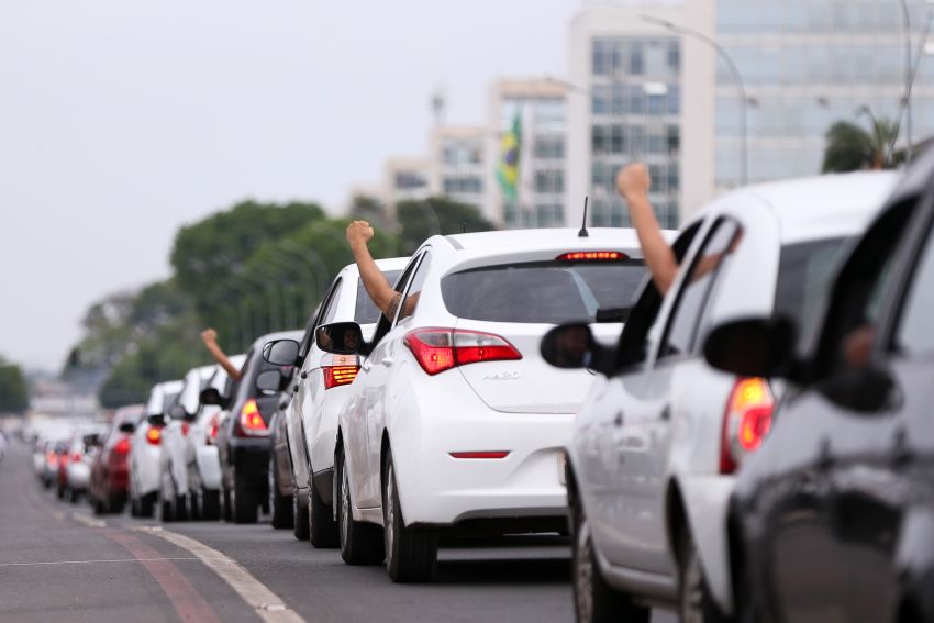 Motoristas levantam os braços em comboio com buzinaço em Brasília
