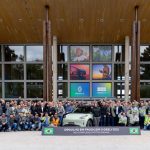 Funcionários da fábrica posam para foto ao lado do Geely EX2