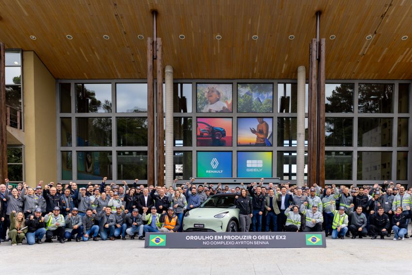 Funcionários da fábrica posam para foto ao lado do Geely EX2